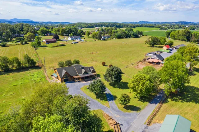 an aerial view of residential houses with outdoor space and lake view