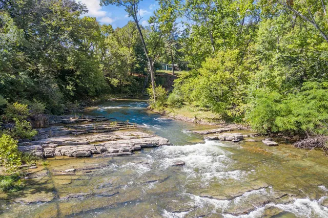 a view of a kitchen with stainless steel appliances granite countertop a sink and wooden floors