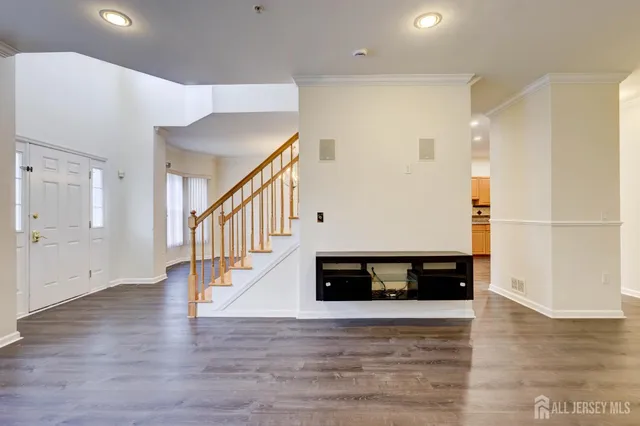 a view of an empty room with wooden floor and a fireplace