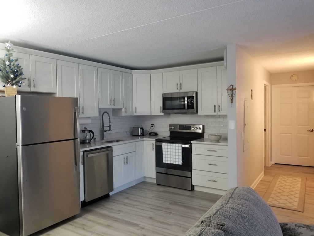 32 Maple Crest Circle, Unit B Holyoke, MA 01040 - Photo 1 of 12 a kitchen with a refrigerator stove and white cabinets