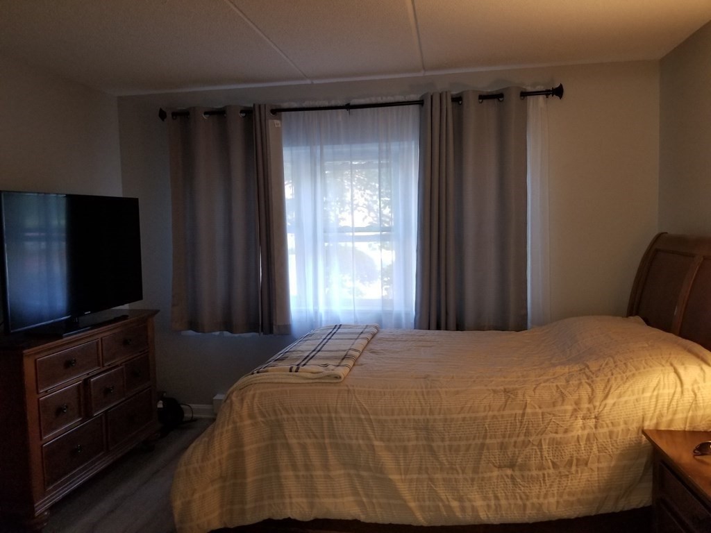32 Maple Crest Circle, Unit B Holyoke, MA 01040 - Photo 8 of 12 a bedroom with a bed tv and a window