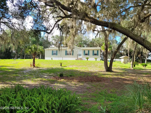 a view of a house with a backyard