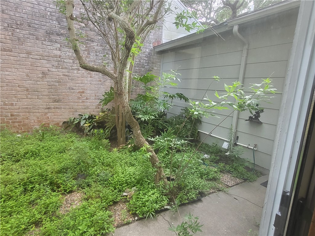 3025 Quail Springs Road, Unit L2 Corpus Christi, TX 78414 - Photo 4 of 19 a backyard of a house with plants and outdoor seating