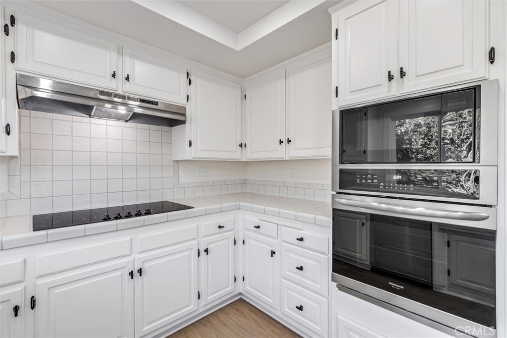 4533 Ironwood Avenue Seal Beach, CA 90740 - Photo 16 of 24 a kitchen with white cabinets and appliances
