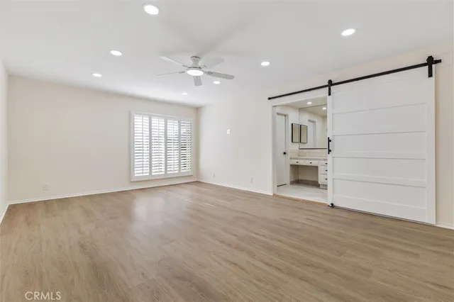 a view of empty room with wooden floor and window