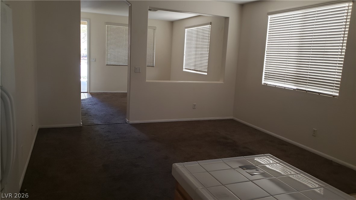 9112 Manalang Road Las Vegas, NV 89123 - Photo 34 of 50 A versatile open-concept space featuring cozy carpeting and abundant natural illumination through multiple windows.