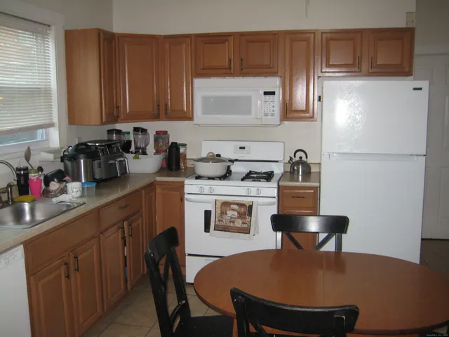 a kitchen with stainless steel appliances granite countertop a sink a stove a refrigerator and cabinets