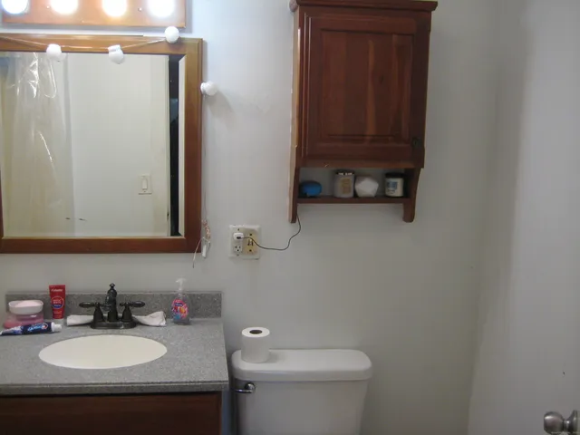 a bathroom with a sink a toilet and mirror