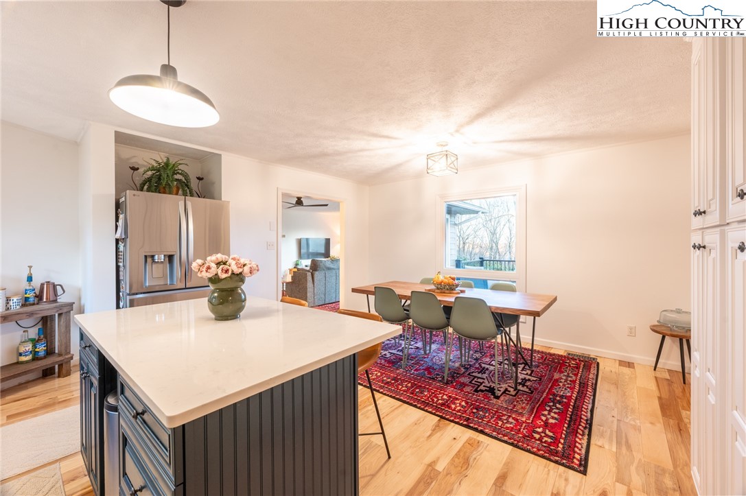197 Sierra Vista Boone, NC 28607 - Photo 17 of 41 a view of a dining room and livingroom with furniture wooden floor a rug a flat screen tv