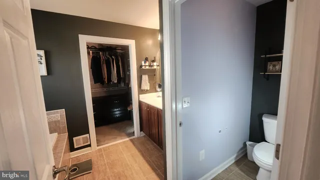 a bathroom with a granite countertop toilet and a sink
