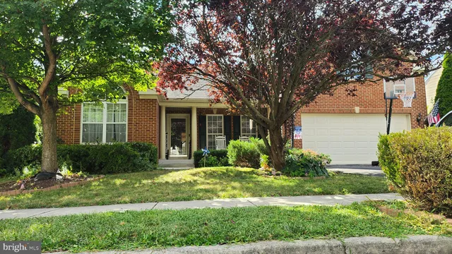 a front view of a house with a yard and potted plants