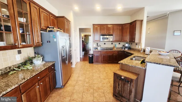 a kitchen with kitchen island granite countertop a sink stove and refrigerator