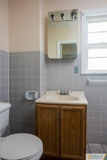 385 Florida Grove Road Perth Amboy, NJ 08861 - Photo 5 of 13 a bathroom with a sink a toilet and mirror