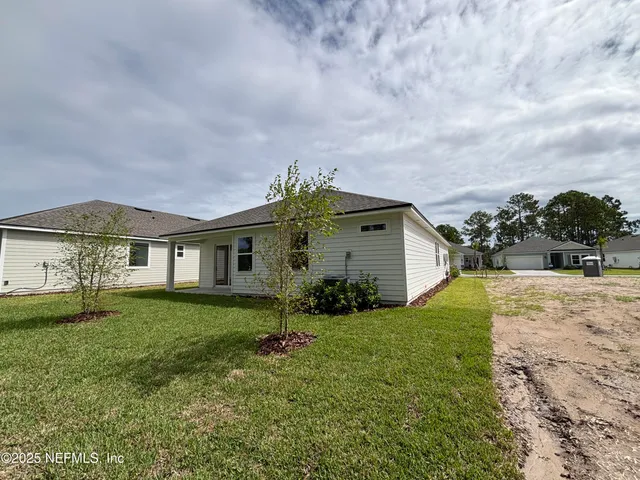 a view of a house with backyard and a tree