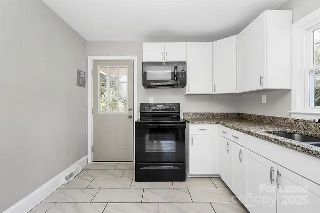 a kitchen with granite countertop white cabinets and stainless steel appliances