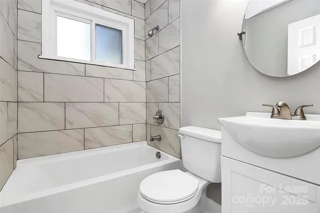 a bathroom with a toilet a sink a mirror and bathtub