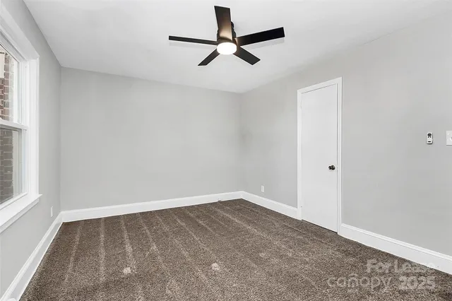 a view of room with a ceiling fan and window