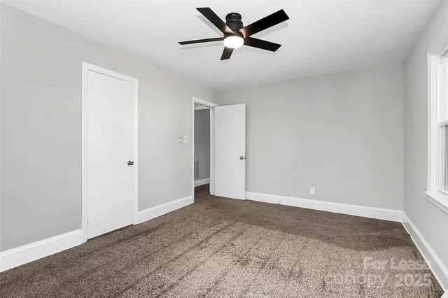a view of a big room with wooden floor and a ceiling fan