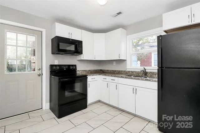 a kitchen with granite countertop a refrigerator stove and microwave