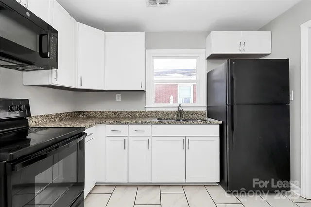 a kitchen with granite countertop a sink stove and refrigerator