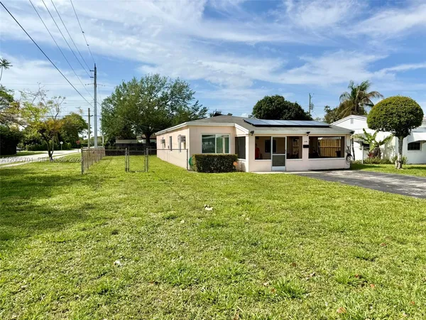 a front view of a house with garden and trees