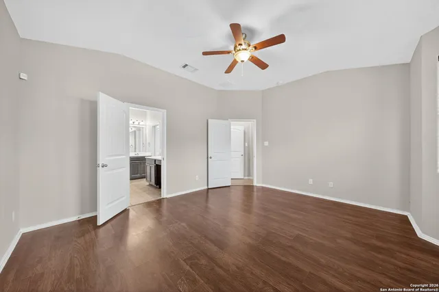 a view of a livingroom with wooden floor and a ceiling fan