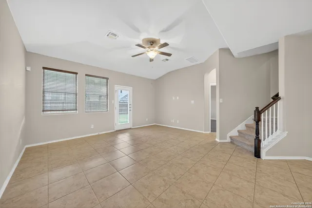 a view of an empty room with a window and a ceiling fan