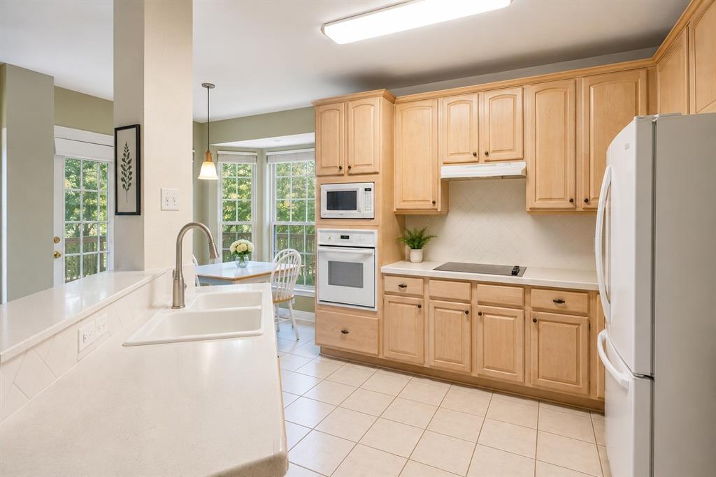 1508 Valley Creek Road Denton, TX 76205 - Photo 17 of 33 a kitchen with white cabinets and white appliances