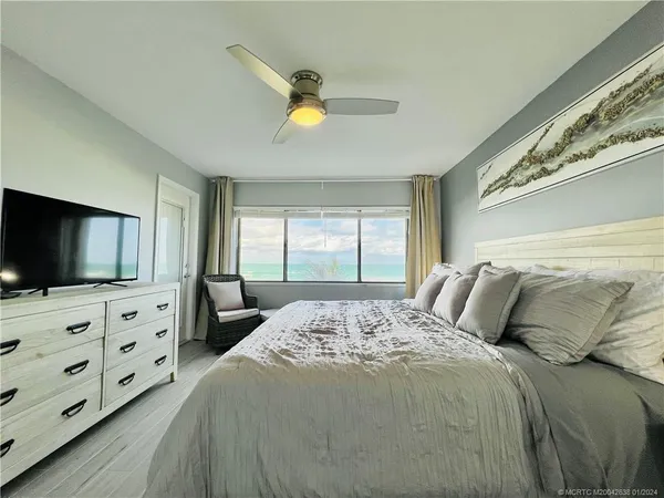 a bedroom with a bed a window and dresser