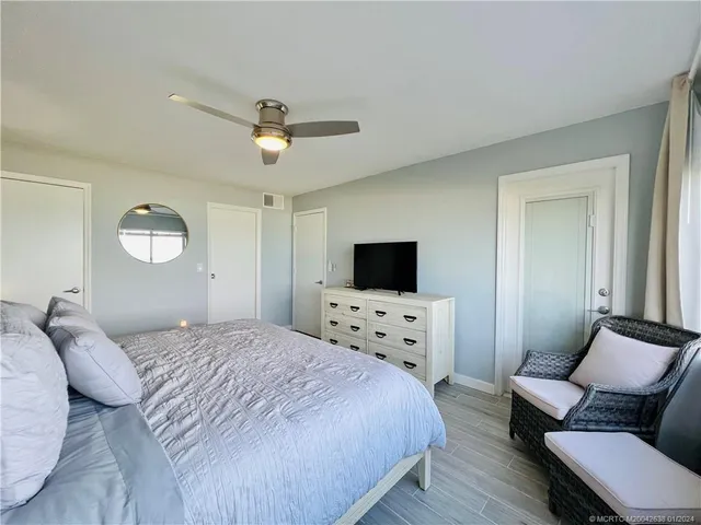 a bedroom with a bed a couch and a flat screen tv