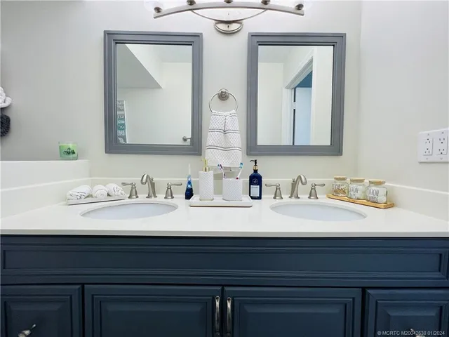 a bathroom with double vanity sinks and a mirror