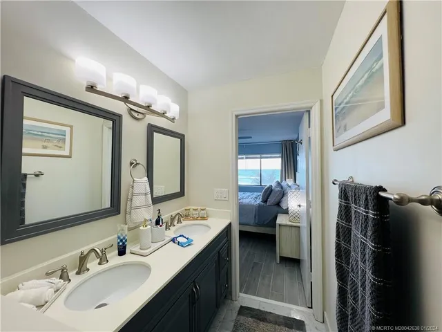 a en suite bathroom with a double vanity sink and a mirror