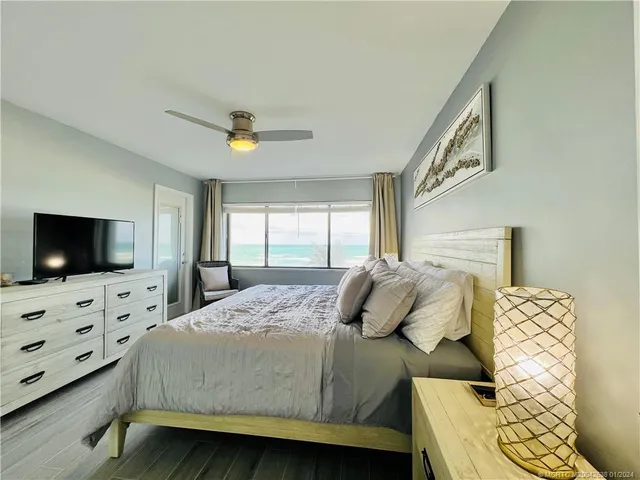 a bedroom with a bed a flat screen tv and dresser