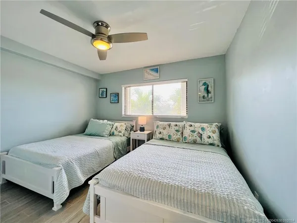 a bedroom with two beds and painting on the wall