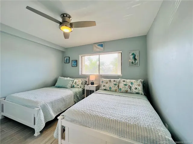 a bedroom with two beds and painting on the wall