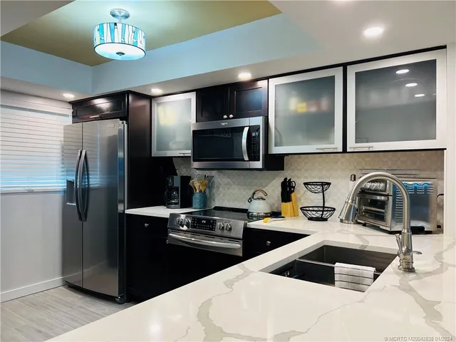 a kitchen with granite countertop a refrigerator and a sink