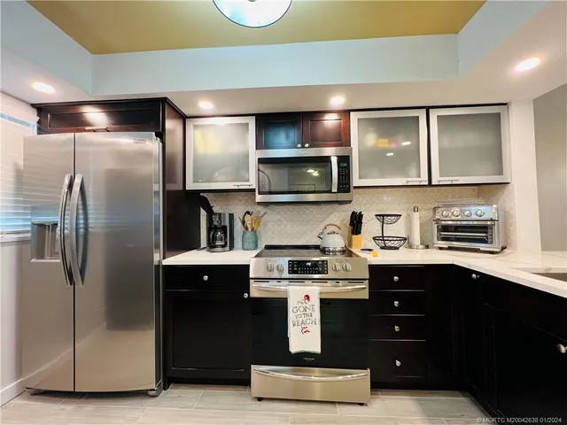 a kitchen with kitchen island a counter space a sink and appliances