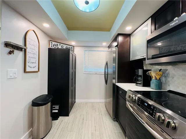 a kitchen with stainless steel appliances granite countertop a refrigerator and a stove