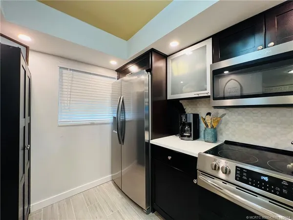 a kitchen with stainless steel appliances granite countertop a refrigerator and a stove top oven
