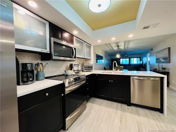 a kitchen with stainless steel appliances granite countertop a sink a stove and cabinets