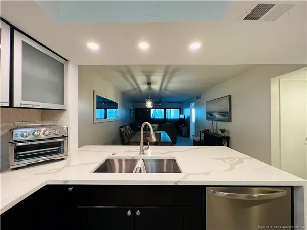 a kitchen with a sink a stove and cabinets