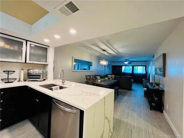 a kitchen with sink refrigerator and cabinets