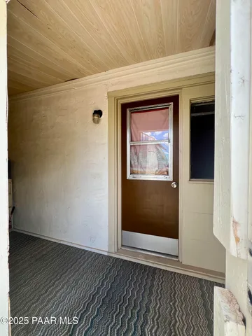 a view of an empty room with wooden floor and closet