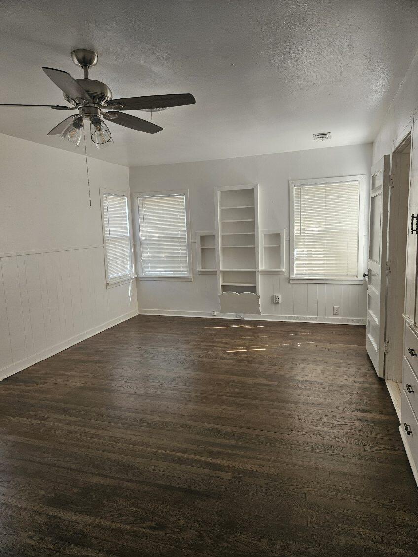 2205 25th Street, Unit FRONT Lubbock, TX 79411 - Photo 14 of 17 an empty room with wooden floor fan and windows