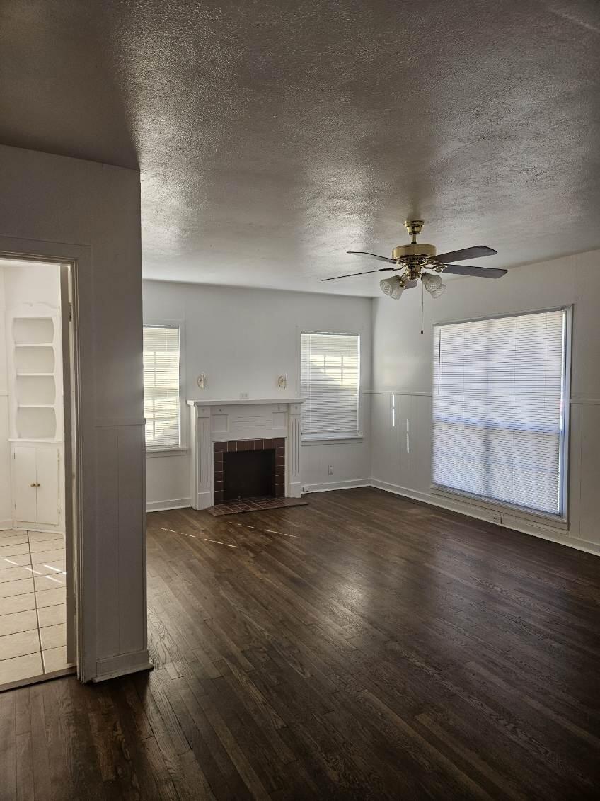 2205 25th Street, Unit FRONT Lubbock, TX 79411 - Photo 2 of 17 an empty room with wooden floor fireplace and windows