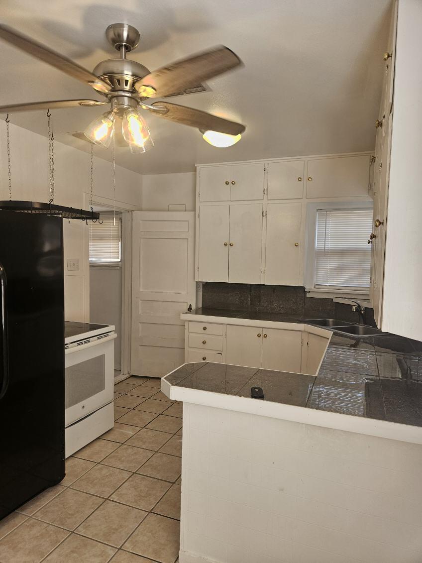 2205 25th Street, Unit FRONT Lubbock, TX 79411 - Photo 4 of 17 a kitchen with a refrigerator and white cabinets