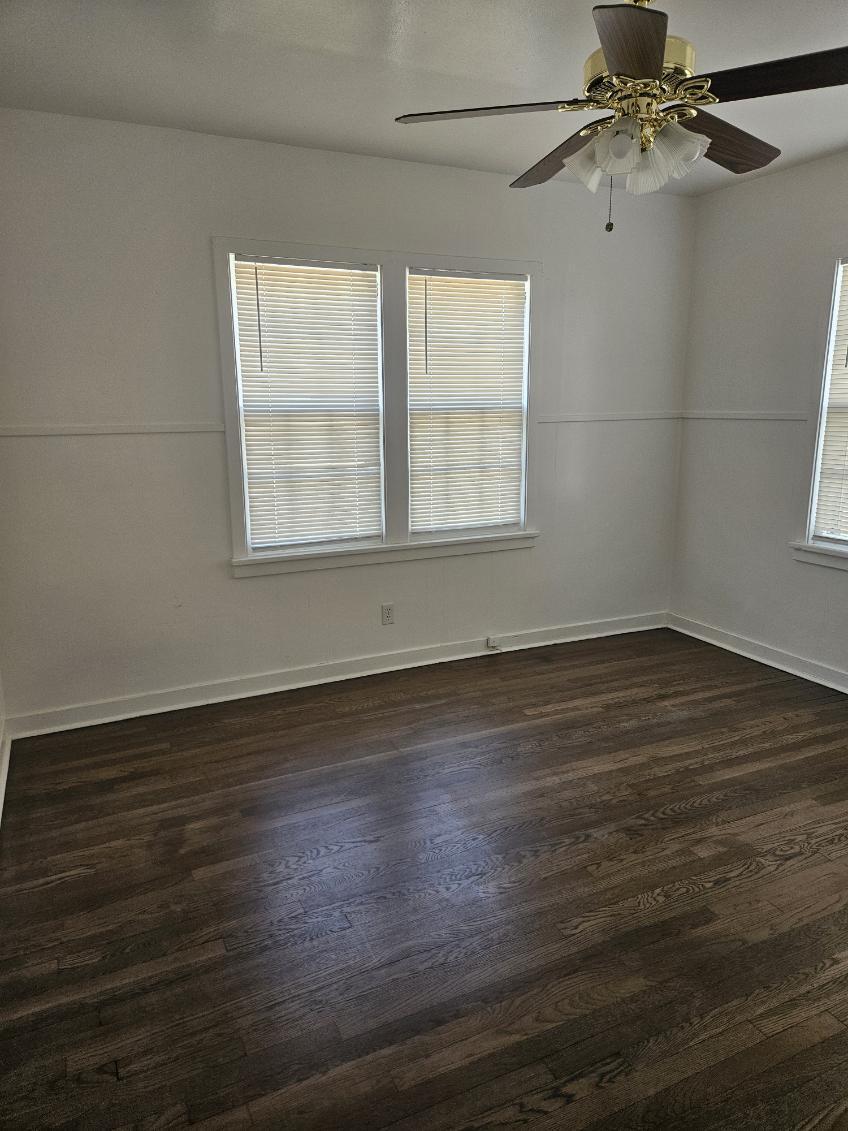 2205 25th Street, Unit FRONT Lubbock, TX 79411 - Photo 10 of 17 an empty room with wooden floor fan and windows