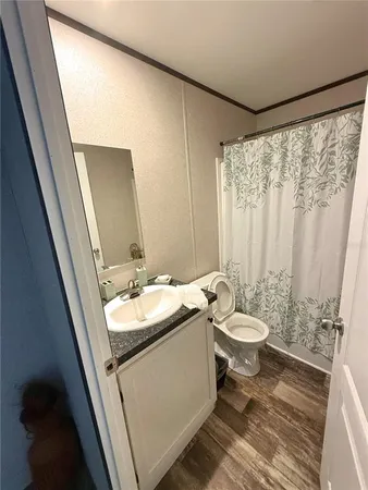 a bathroom with a granite countertop sink toilet and mirror