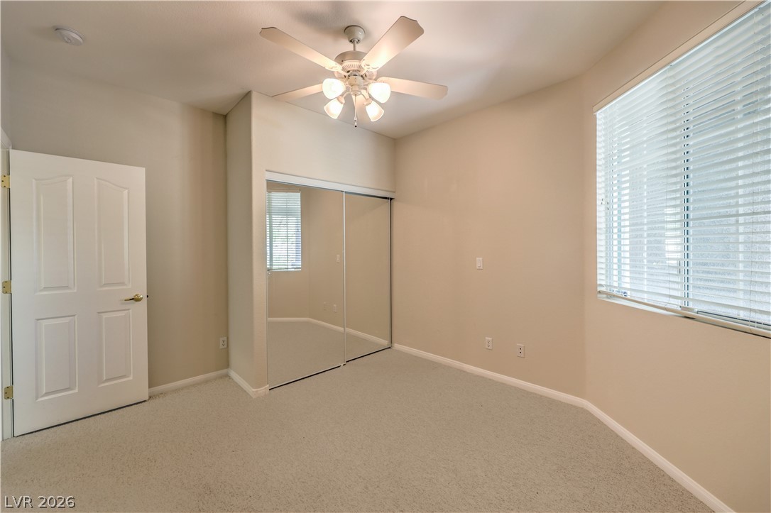 3713 Spring Shadow Road Las Vegas, NV 89129 - Photo 29 of 37 This naturally illuminated bedroom offers mirrored closet doors, soft carpeting, and a ceiling fan for comfort.