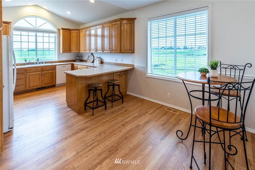 9147 Benson Road Lynden, WA 98264 - Photo 11 of 40 a kitchen with stainless steel appliances granite countertop wooden cabinets a sink and dishwasher with wooden floor